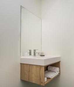 a bathroom with a sink and a mirror at Hôtel le Corbusson in Saint-Berthevin