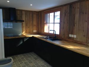 a kitchen with wooden walls and a sink and a window at chalet clémentine in La Tania