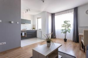a living room with a table and a kitchen at Corvin Plaza Apartments & Suites in Budapest