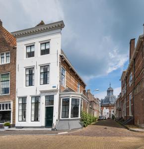 un bâtiment blanc au milieu d'une rue dans l'établissement Logement de Spaerpot, à Middelbourg