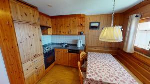 a kitchen with wooden cabinets and a table in it at Am Färrichlift in Belalp