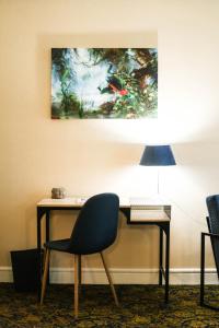 a desk with a chair and a painting on the wall at Aux Portes du Château in Valençay