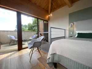 1 dormitorio con cama, sillas y balcón en Auberge de la Tour de Brison en Sanilhac
