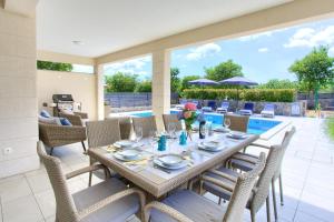 comedor con mesa, sillas y piscina en Villa Magdalena, en Porat