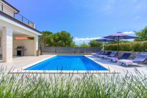 una piscina con tumbonas y sombrilla en Villa Magdalena, en Porat