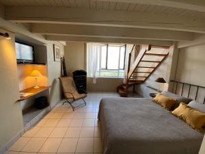 een slaapkamer met een bed en een trap in een kamer bij Auberge de la Tour de Brison in Sanilhac
