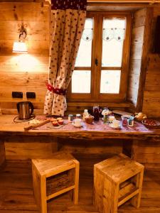 een houten kamer met een tafel, banken en een raam bij Ospitalità rurale familiare Land Wasser in Varallo