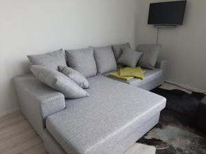 un sofá gris con almohadas en la sala de estar en Villa Hiili en Ähtäri