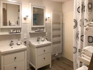 Baño blanco con 2 lavabos y espejo en Ferienwohnung im Zentrum Brilons en Brilon
