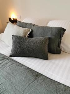 a bed with pillows and pillows on it at Hotel Restaurant La Musardiere in Giverny