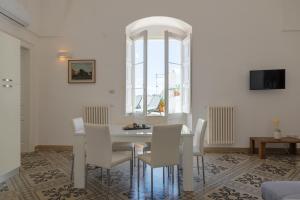 jadalnia z białym stołem i krzesłami w obiekcie Palazzo Le Cupole by Wonderful Italy w mieście Ostuni