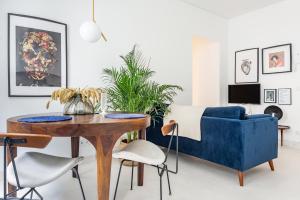 uma sala de estar com uma mesa e um sofá azul em Decompress at a Tranquil, Minimal Urban Oasis with an Edge no Porto