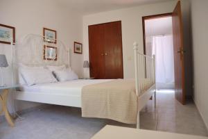 a bedroom with a white bed and a staircase at Salema Beach Private Villa in Salema