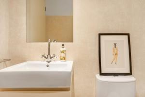 uma casa de banho com um lavatório, um WC e uma fotografia em Decompress at a Tranquil, Minimal Urban Oasis with an Edge no Porto