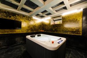a bath tub in a room with a tv at Apartments in Kaunas city centre with Jacuzzi bath in Kaunas