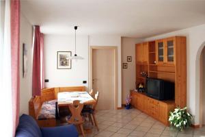 a living room with a table and a dining room at Appartamenti Piazzi in Tesero