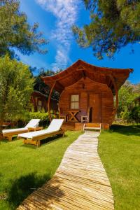 eine Blockhütte mit einem Gehweg im Gras in der Unterkunft Green Pine Bungalows & Beach Luxury Concept in Oludeniz