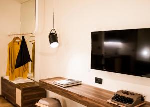 a room with a television and a lamp at Gaia Athens in Athens