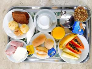 a tray full of food including a sandwich, fruit, and milk at Savassi Village in Belo Horizonte