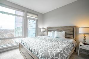 a bedroom with a bed and a large window at Heaven On Baltimore Downtown Fully Furnished Apartments in Baltimore