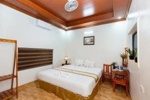 a bedroom with a large bed and a desk at Tam Coc Tuong Vy Homestay in Ninh Binh