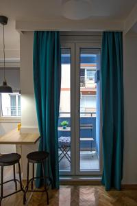 sala de estar con cortinas azules, mesa y sillas en DK Apartment, en Novi Sad