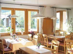 a restaurant with tables and chairs and windows at Apart-Garni Motnaida in Samnaun