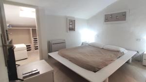 ein weißes Schlafzimmer mit einem Bett und einem Spiegel in der Unterkunft Porto Rotondo in Porto Rotondo