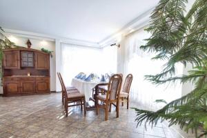 a dining room with a table and chairs and a christmas tree at Rezydencja Viva in Poronin