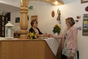 Duas mulheres ao balcão de um salão de cabeleireiro. em Ferienhotel Kollmerhof em Rimbach