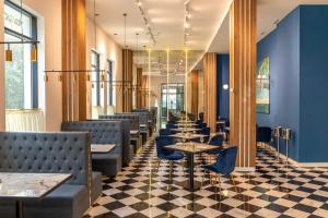 a row of tables and chairs in a restaurant with blue walls at Newport Hotel Kutaisi in Kutaisi