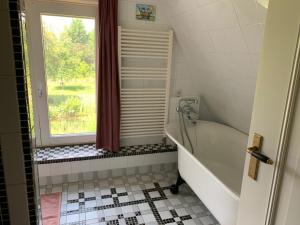 Jelsum的住宿－B&B Pastorie Jelsum，带浴缸和窗户的浴室