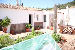 einen Garten mit einem Zaun, einem Tisch und Stühlen in der Unterkunft Salema Beach Private Villa in Salema