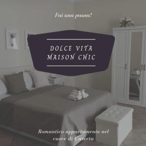 卡塞塔的住宿－Dolce Vita maison chic，卧室里读过维塔传教诊所的标志