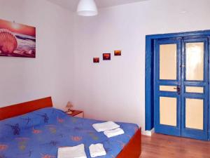 a bedroom with a bed and a blue door at Flamingo Room in Castellammare del Golfo