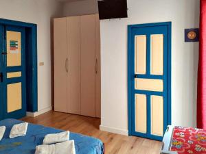 a room with two blue doors and a bed at Flamingo Room in Castellammare del Golfo