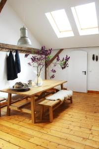a dining room with a wooden table and a bench at WERKGUT - charmantes großzügiges Loft im Naturpark in Meezen +19 photos