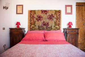 a bedroom with a bed with red pillows and two lamps at Borgo Antico - Torre Pugliola in Lerici