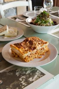 a table with plates of food and a bowl of salad at Kalamitsi Hotel in Kardamyli