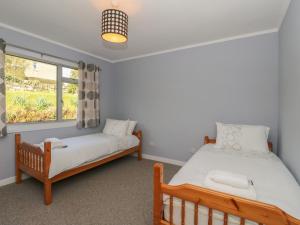 2 camas en una habitación con ventana en Am Bruaich, en Lochgilphead