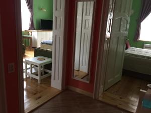 Habitación con paredes verdes y puerta con espejo. en Апартамент ELSOR en Burgas