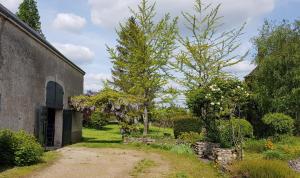 a garden with two trees next to a building at La Maison Josnes de Mady in Josnes