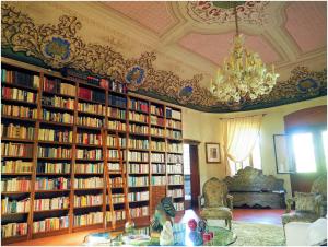 una biblioteca con estanterías llenas de libros en Villa Contessa Massari Ferrara, en Ferrara