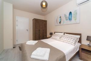 a bedroom with a large bed with two towels on it at Alma Apartment - Stylish 1BD Flat with Balcony by Flat Mаnager in Plovdiv