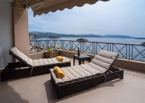 een balkon met twee banken en uitzicht op het water bij King Minos Hotel in Tolo
