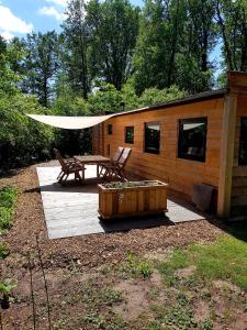 een houten hut met een picknicktafel en een bank bij Boshut C43 in Nutter