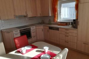 eine kleine Küche mit einem Tisch und einem roten Stuhl in der Unterkunft Am Mühlbach in Sinsheim
