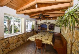 a dining room with a table and a stone wall at Apartmani Križanović in Vodice