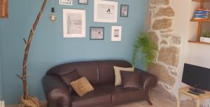 un sofá de cuero marrón en una sala de estar con TV en O FOGAR DE MARTIÑO, en Vilagarcía de Arousa