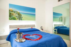 Un dormitorio con una cama azul con un collar de corazón rojo en Anna e Augusto B&B, en Lucera
